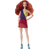 Muñeca Barbie con pelo rojo rizado, vestida con un top de bloques de color y una falda de piel sintética brillante, posable hecha para mover el cuerpo